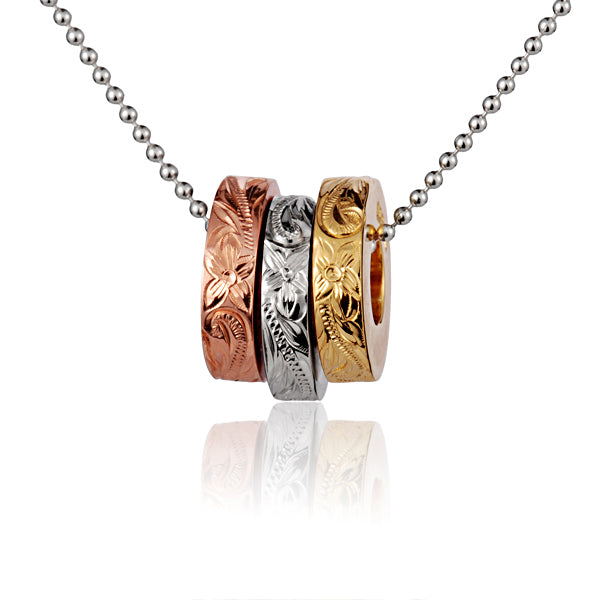 The photo shows a three-tone yellow, white, and rose gold vermeil ring pendant with a scroll engraved.