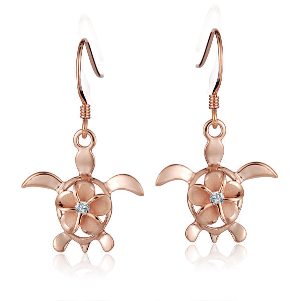 The photo shows a pair of rose gold vermeil sea turtle hook earrings featuring a plumeria flower with a cubic zirconia gem.