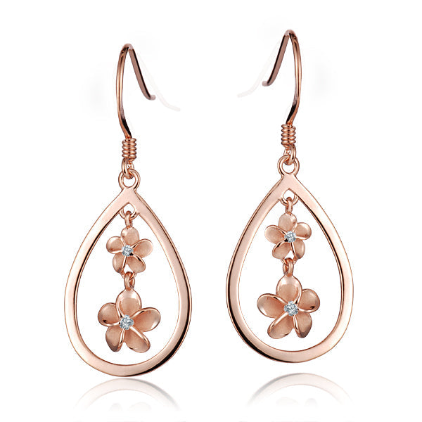 The photo shows a pair of rose gold vermeil plumeria hook earrings featuring a teardrop design with cubic zirconia.