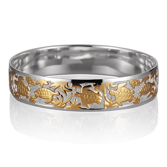 The photo is a two-tone white and yellow gold vermeil swimming turtle bangle. 
