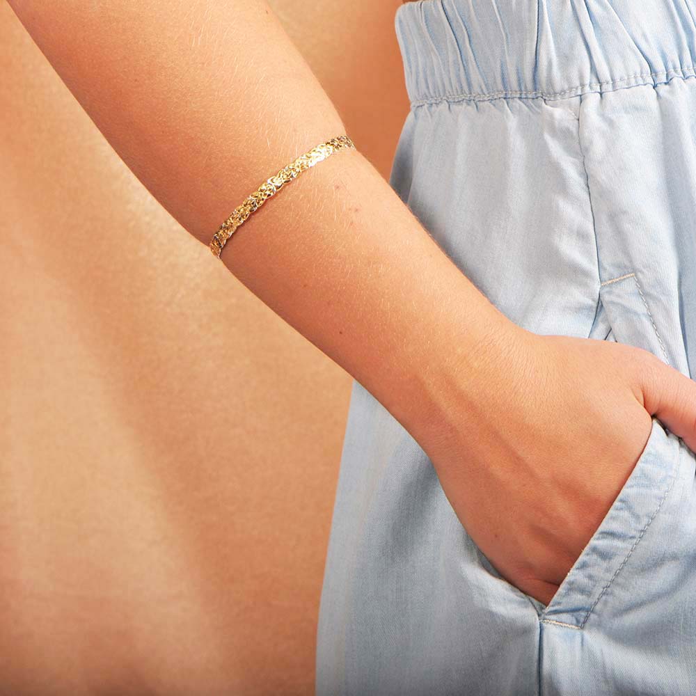 Gold vermeil bangle with a plumeria engraved design that is 6mm thick.