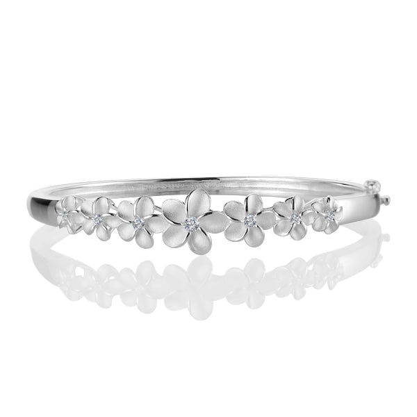 The photo shows a plumeria bangle made of sterling silver with cubic zirconia gems. 
