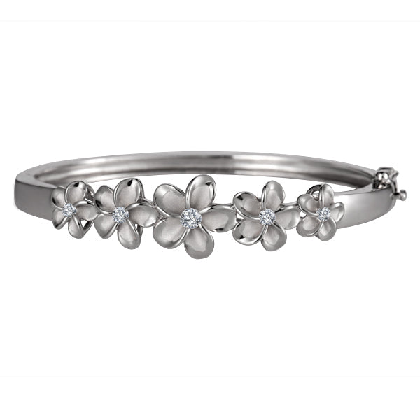 The picture has a sterling silver bangle with white gold vermeil rhodium plated plumerias and cubic zirconia gems.