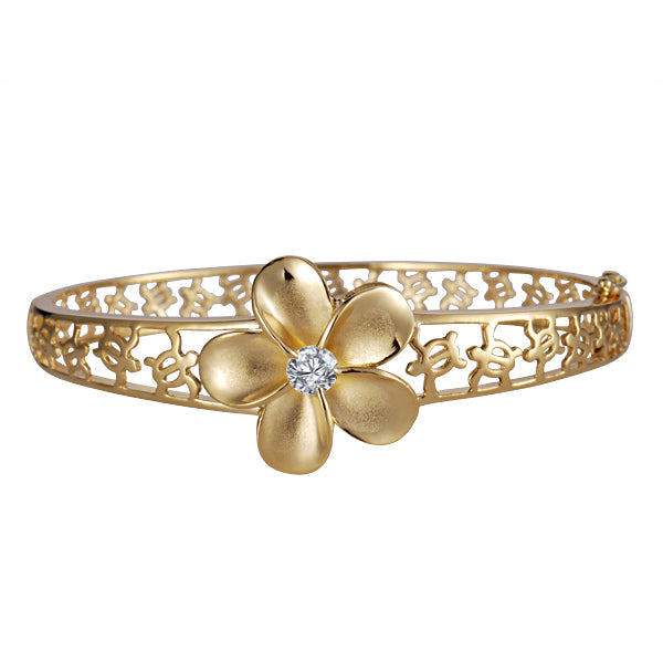 The photo shows a yellow gold vermeil rhodium plated plumeria flower bangle featuring sea turtles and cubic zirconia.  