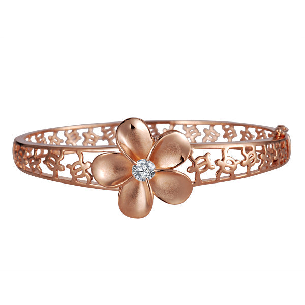 The photo shows a rose gold vermeil rhodium plated flower bangle featuring sea turtles and cubic zirconia.  