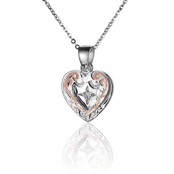 The photo shows a two-tone sterling silver rose gold vermeil heart pendant featuring a scroll motif and a cubic zirconia gemstone. 