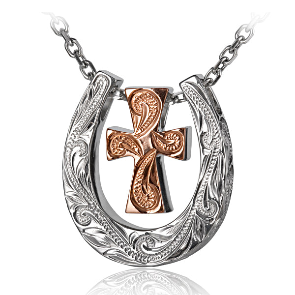 The photo shows a white gold vermeil scroll horse shoe pendant featuring a yellow gold cross design.