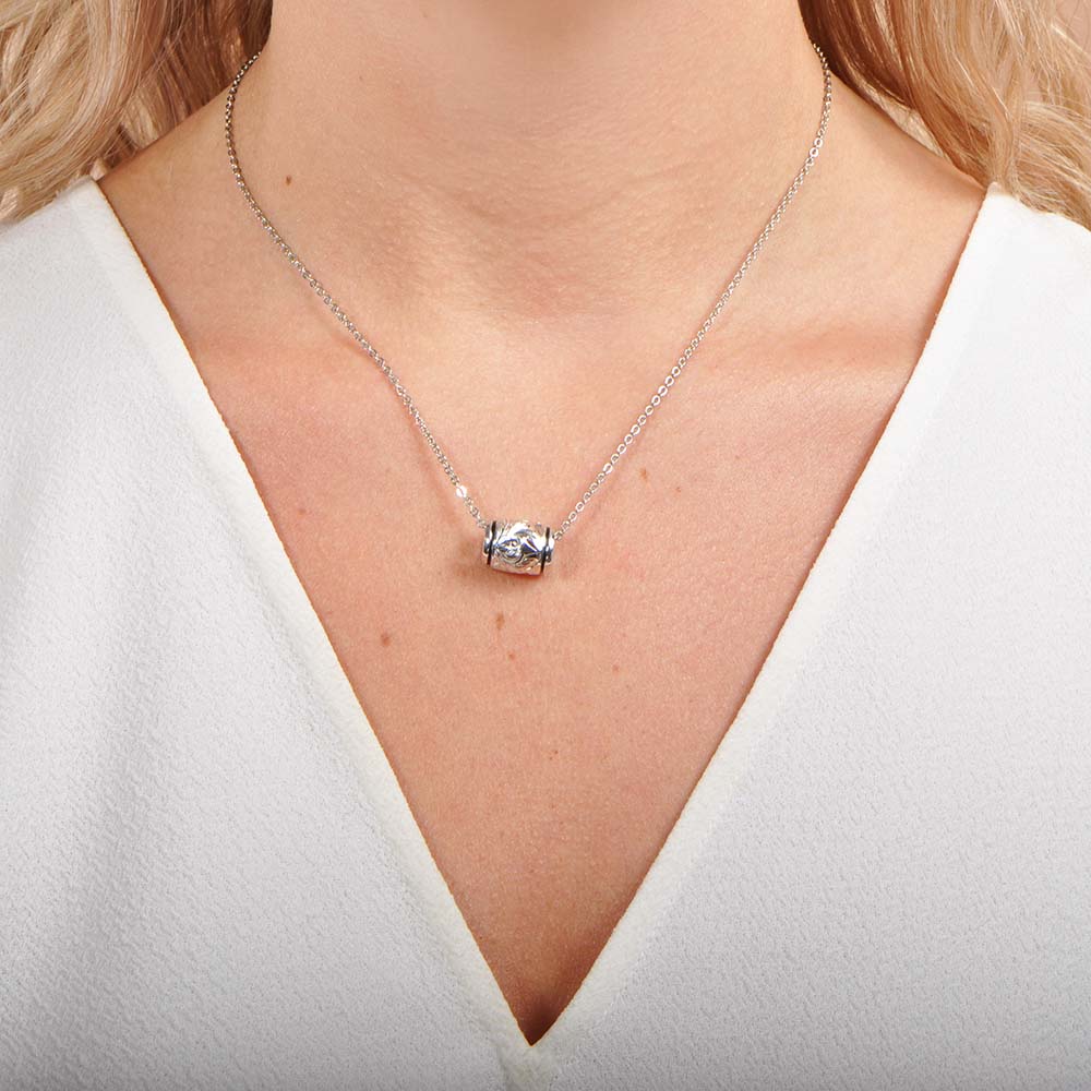 The photo shows the front of a model wearing a sterling silver barrel pendant. 