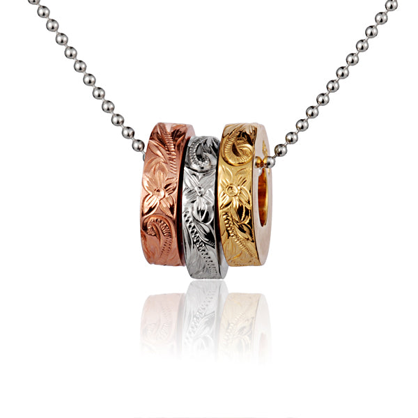 The photo shows a three-tone yellow, white, and rose gold vermeil ring pendant with a scroll engraved. 