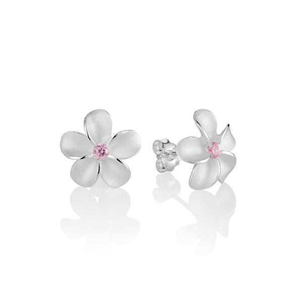 The photo is a pair of matte finish sterling silver white gold vermeil plumeria stud earrings with pink cubic zirconia stones.