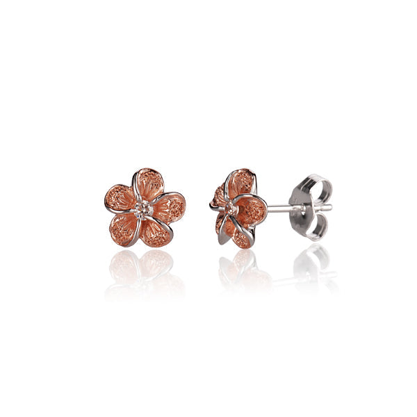 The photo shows a pair of rose gold vermeil plumeria frost stud earrings. 