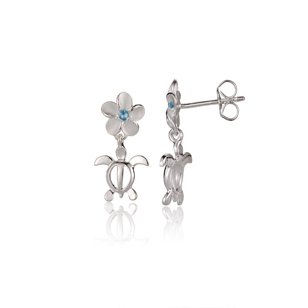 The photo is a pair of 6 mm flower stud earrings made of sterling silver, featuring a sea turtle motif and a blue cubic zirconia gem.