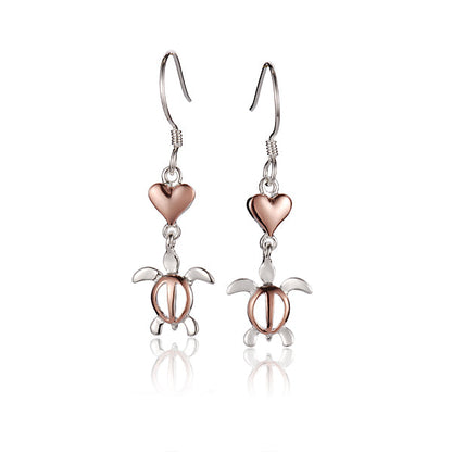The photo shows a pair of two-tone rose and white  gold vermeil heart earrings featuring a sea turtle motif. 