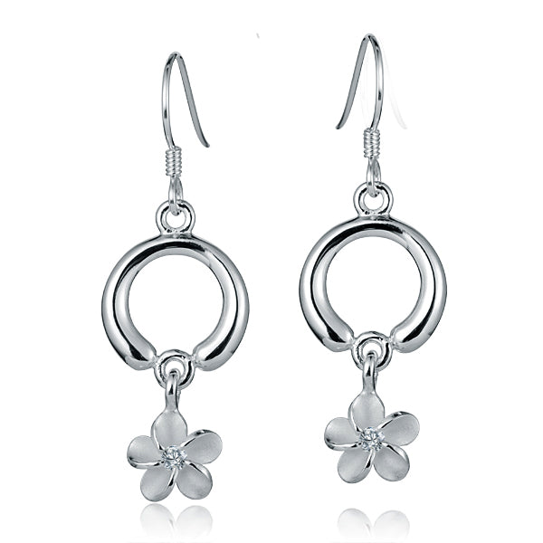 The photo shows a pair of circle dangle plumeria earrings with a sustainable clear cubic zirconia gem. 