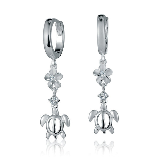 The picture shows a pair of sterling silver dangling hoop earrings featuring a plumeria and sea turtle motif with cubic zirconia.