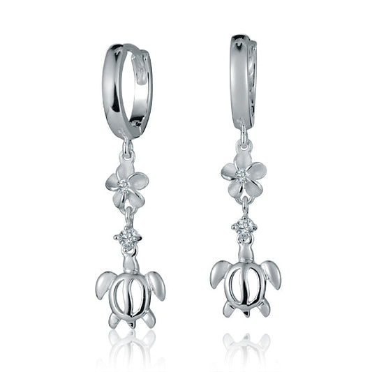 The picture shows a pair of sterling silver dangling hoop earrings featuring a plumeria and sea turtle motif with cubic zirconia.
