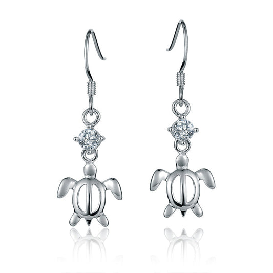 The photo shows a pair of sterling silver cubic zirconia sea turtle dangle hook earrings.