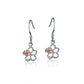 The photo shows a pair of sterling silver hook hibiscus earrings with details in rose gold vermeil and a clear eco-gem.