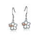 The photo shows a pair of sterling silver hook hibiscus earrings with details in rose gold vermeil and a clear eco-gem.