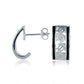 The photo shows a pair of sterling silver sea turtle stud earrings with black borders. 
