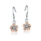 The photo shows a two-tone rose and silver rhodium plated plumeria hook earrings with cubic zirconia. 