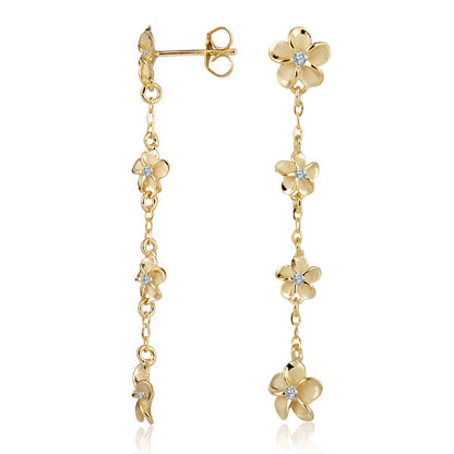 The photo shows a pair of yellow gold vermeil plumeria flower dangle stud earrings with cubic zirconia gems. 