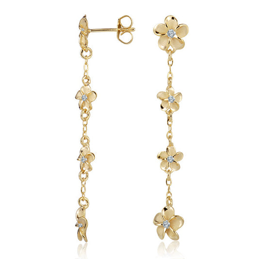 The photo shows a pair of yellow gold vermeil plumeria flower dangle stud earrings with cubic zirconia gems. 