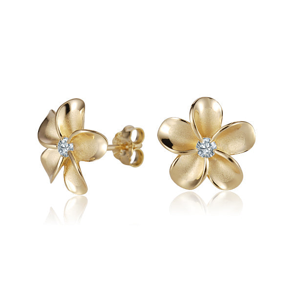 The photo shows a pair of yellow gold vermeil flower stud earrings with cubic zirconia gemstones.