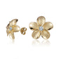 The photo shows a pair of yellow gold vermeil plumeria stud earrings with cubic zirconia gemstones.
