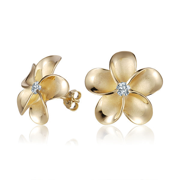 The photo shows a pair of yellow gold vermeil flower stud earrings with cubic zirconia gemstones.