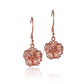 The photo shows a pair of rose gold vermeil hibiscus hook earrings. 