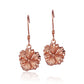The picture has a pair of rose gold vermeil hibiscus hook earrings. 