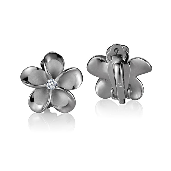 The photo shows a pair of sterling silver 18mm plumeria clip earrings with a clear cubic zirconia gem.