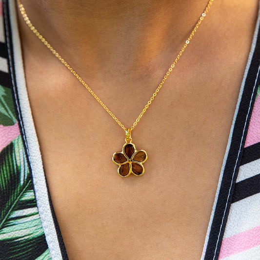 14K gold vermeil and Koa wood plumeria pendant. the pendant is worn by a model.